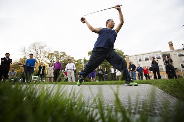 Chia Chue Yang demonstrates the game of Tuj Lub for onlookers and media during the grand opening of the state's first Tuj Lub courts in St. Paul.