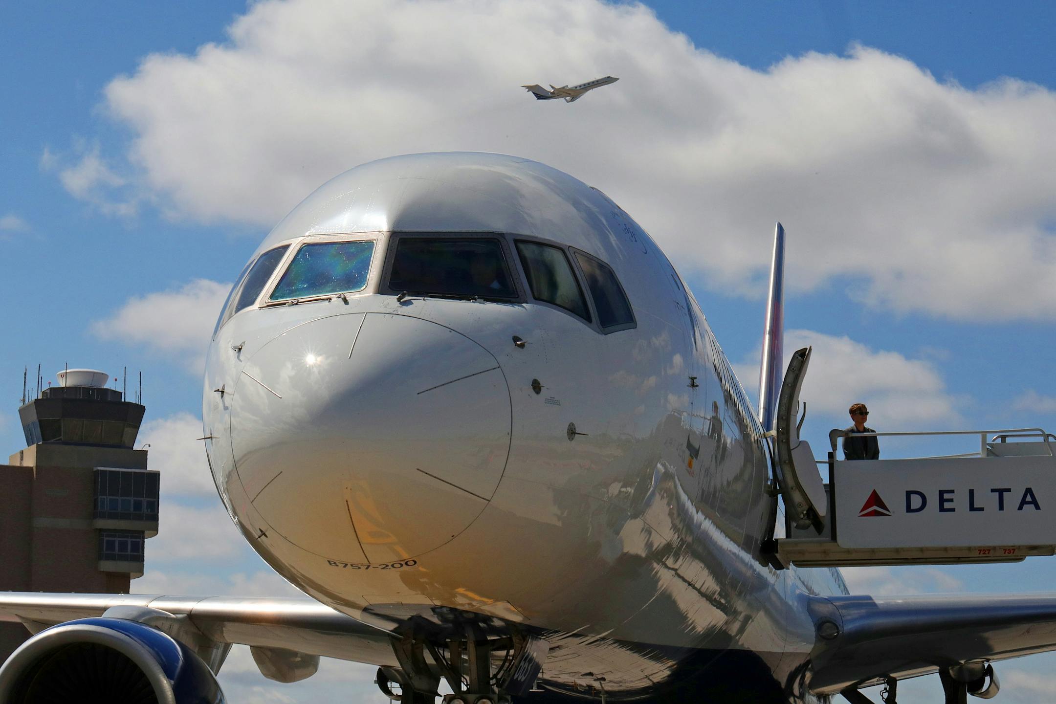 A Federal Aviation Administration official waited for members of the media to deplane after Delta pilot Jon Michael Pendleton explained the FAA's Next Generation Air Transportation System from the cockpit of an aircraft Tuesday.