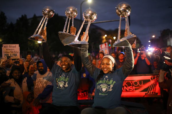 Lynx stars Sylvia Fowles, left, and Maya Moore held up all four WNBA championship trophies as the team arrived at Williams Arena for a celebration of 