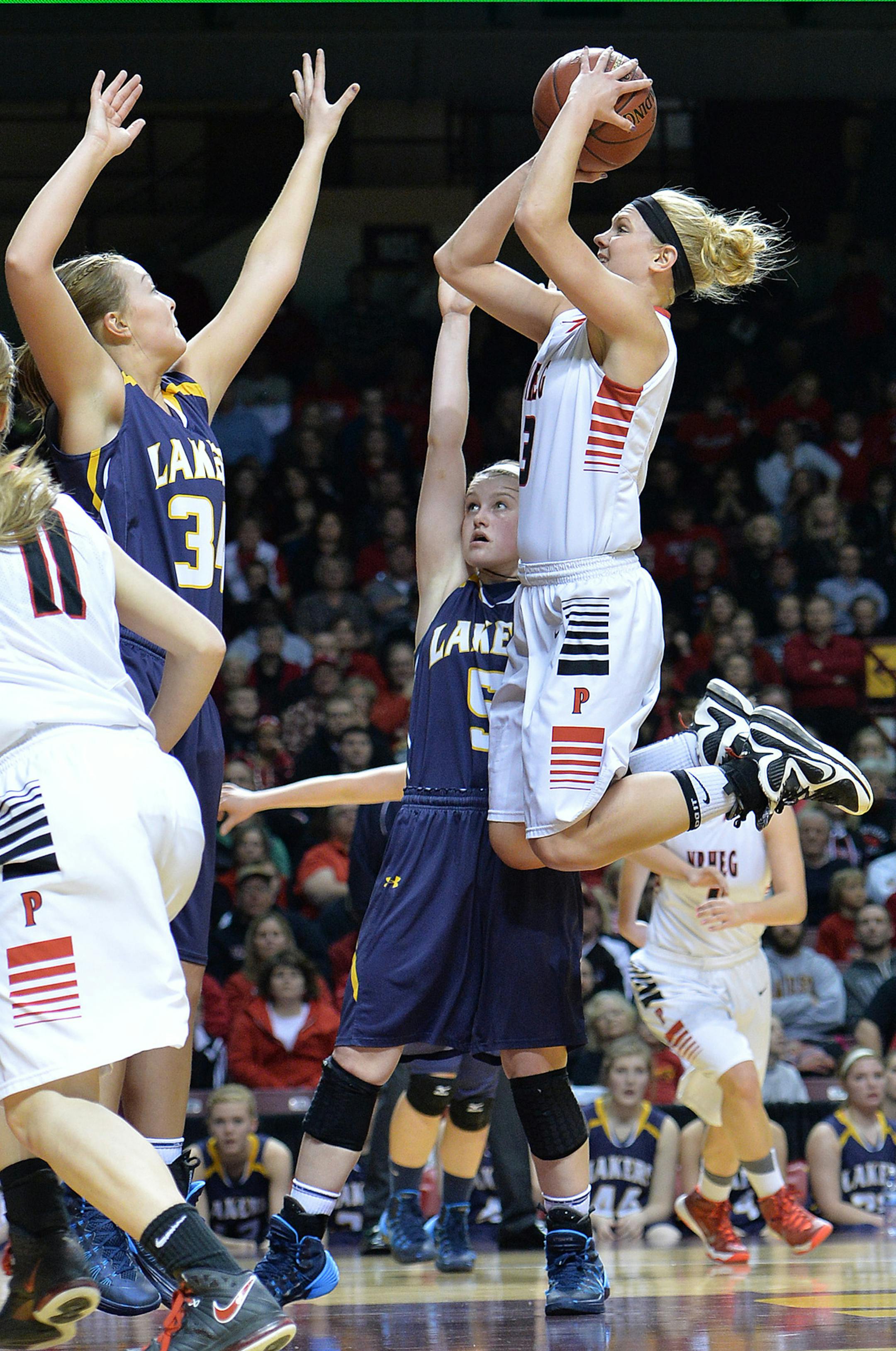 New Richland-H-E-G's Carlie Wagner goes up for a shot against Howard Lake-W-W's Marissa Reed during the first half of a semifinal game of the Class 2A girls' state basketball tournament Friday night at Williams Arena. New Richland-H-E-G led Howard Lake-W-W 40-28 at halftime. ] (SPECIAL TO THE STAR TRIBUNE/BRE McGEE) **Carlie Wagner (white, 3), Marissa Reed (blue, 34)