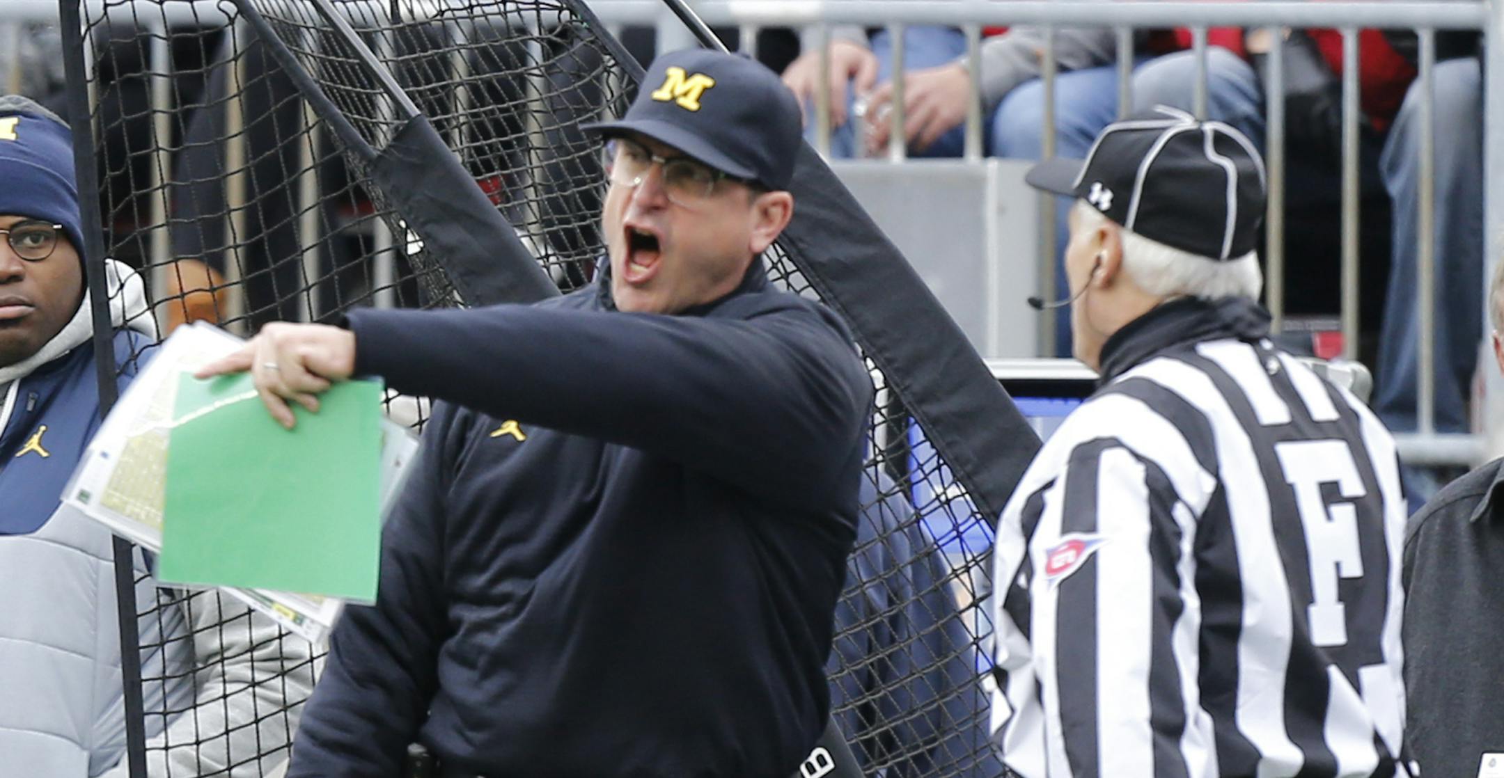 Michigan head coach Jim Harbaugh, left, yells at the field judge during the first half of an NCAA college football game against Ohio State, Saturday, Nov. 26, 2016, in Columbus, Ohio. Ohio State beat Michigan 30-27 in double overtime. (AP Photo/Jay LaPrete)