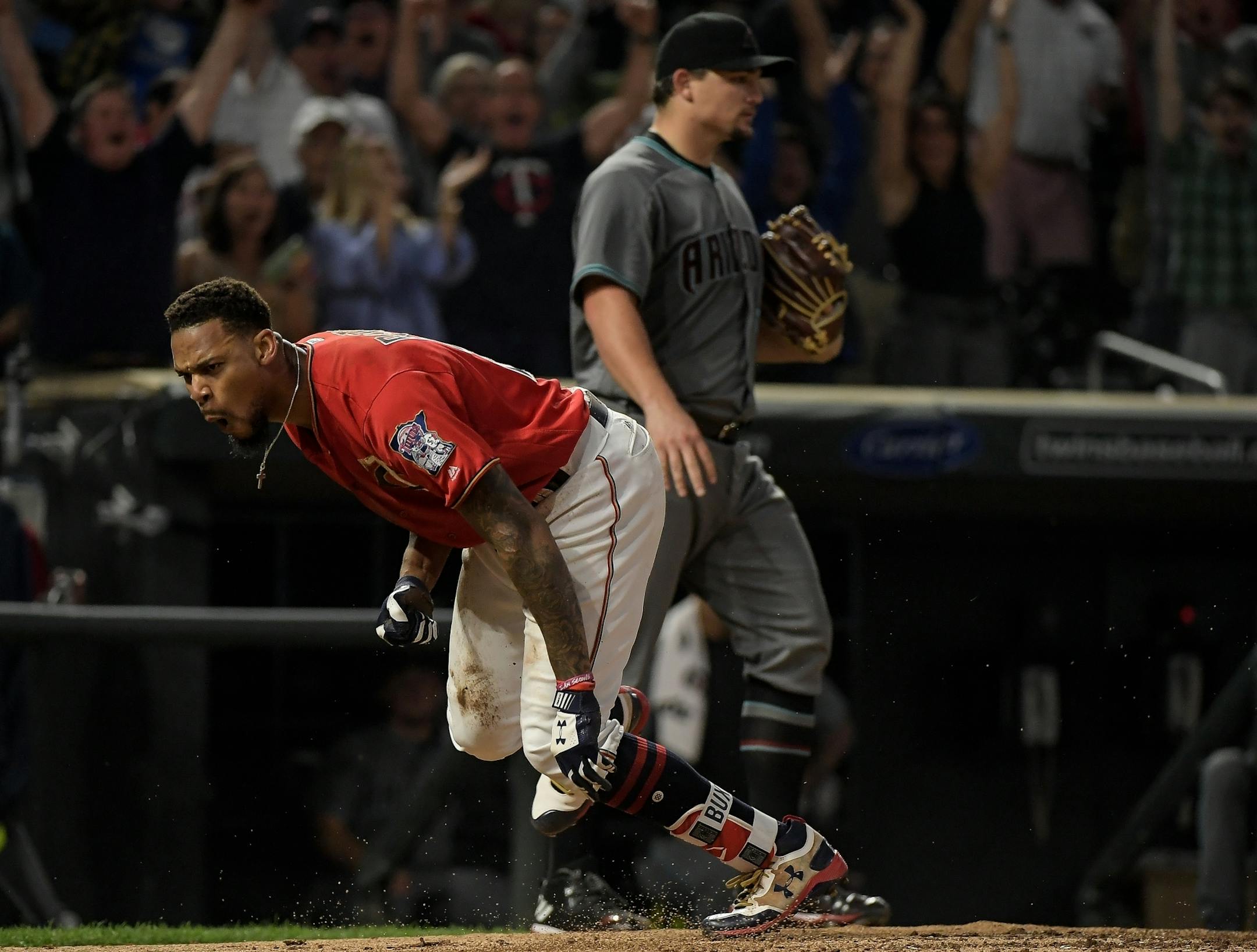 Minnesota Twins center fielder Byron Buxton (25) celebrated his inside-the-park home run in the bottom of the fourth inning as Arizona Diamondbacks starting pitcher Zack Godley (52) walked behind him.