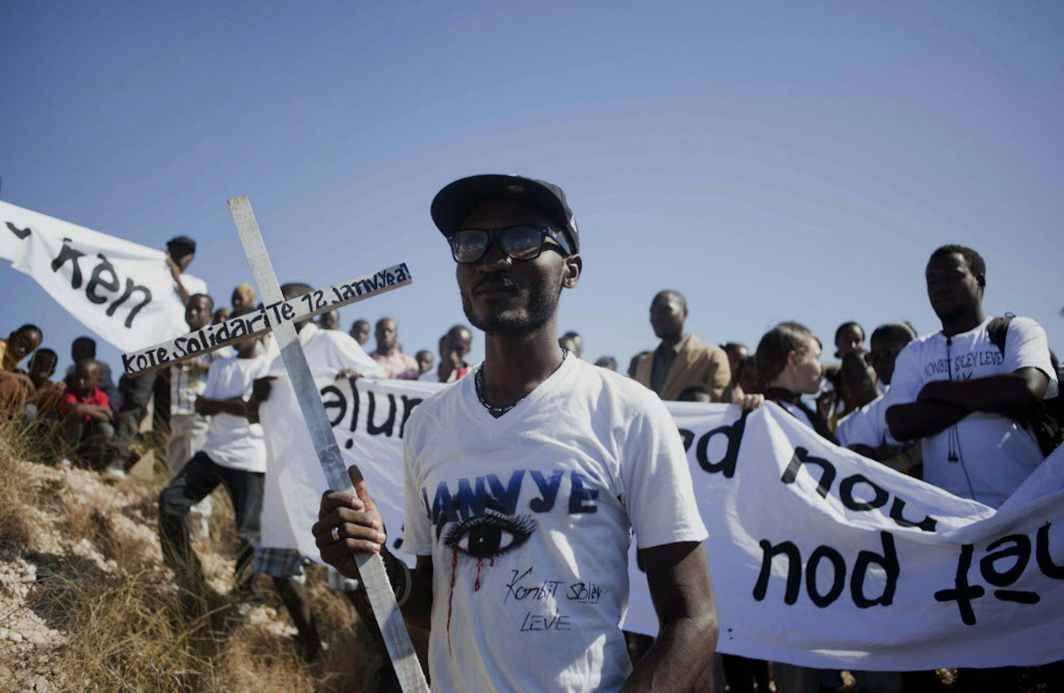 Jan. 12, 2014: Relatives walk to a hilltop, where they will place crosses, in remembrance of those family members who died in the 2010 earthquake, prior to a memorial service in Titanyen, north of Port-au-Prince, Haiti. Haitians are pausing to remember the tens of thousands of people who died in the 7.0-magnitude earthquake that left 1.5 million people living in tent camps. Officials say more than 300,000 died, but no one knows for certain.