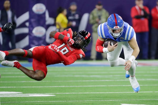 Texas Tech defensive back Tyler Owens (18) upends the run by Mississippi quarterback Jaxson Dart, right, during the first half of the Texas Bowl NCAA 