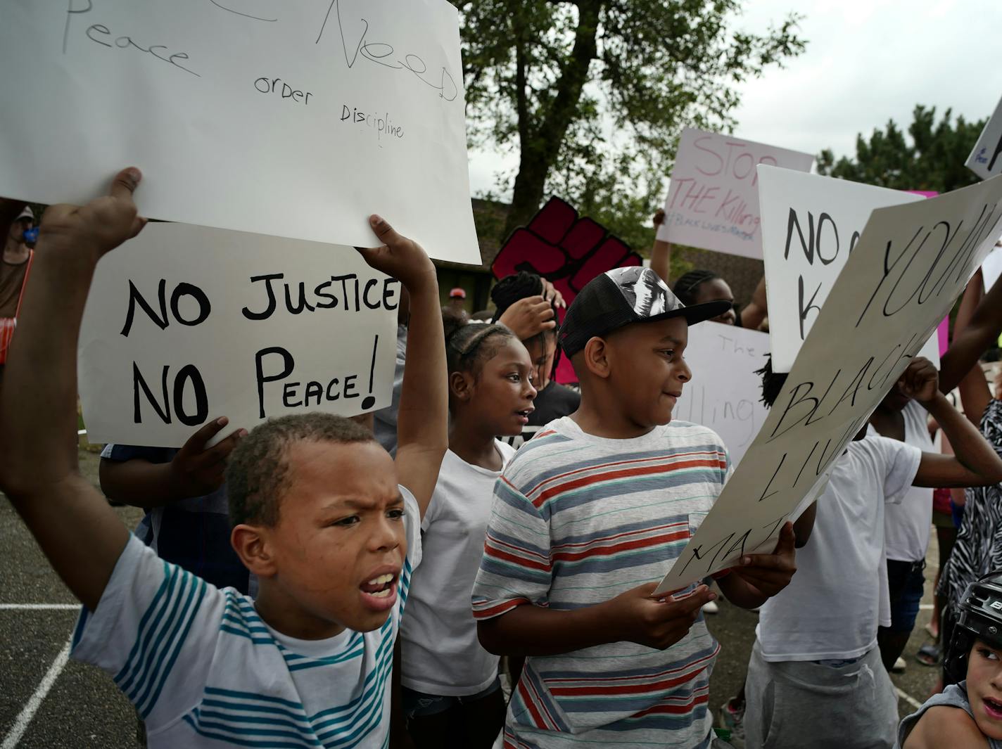 Jeremiah Williams,10,far left, held a sign that said,"We need peace order discipline.]" Next to him was Milo Young, 10. ]At JJ Hill Montessori Magnet School, children marched there to protest the shooting death of Philander Castile, who worked at the school.Richard Tsong-taatarii@startribune.com