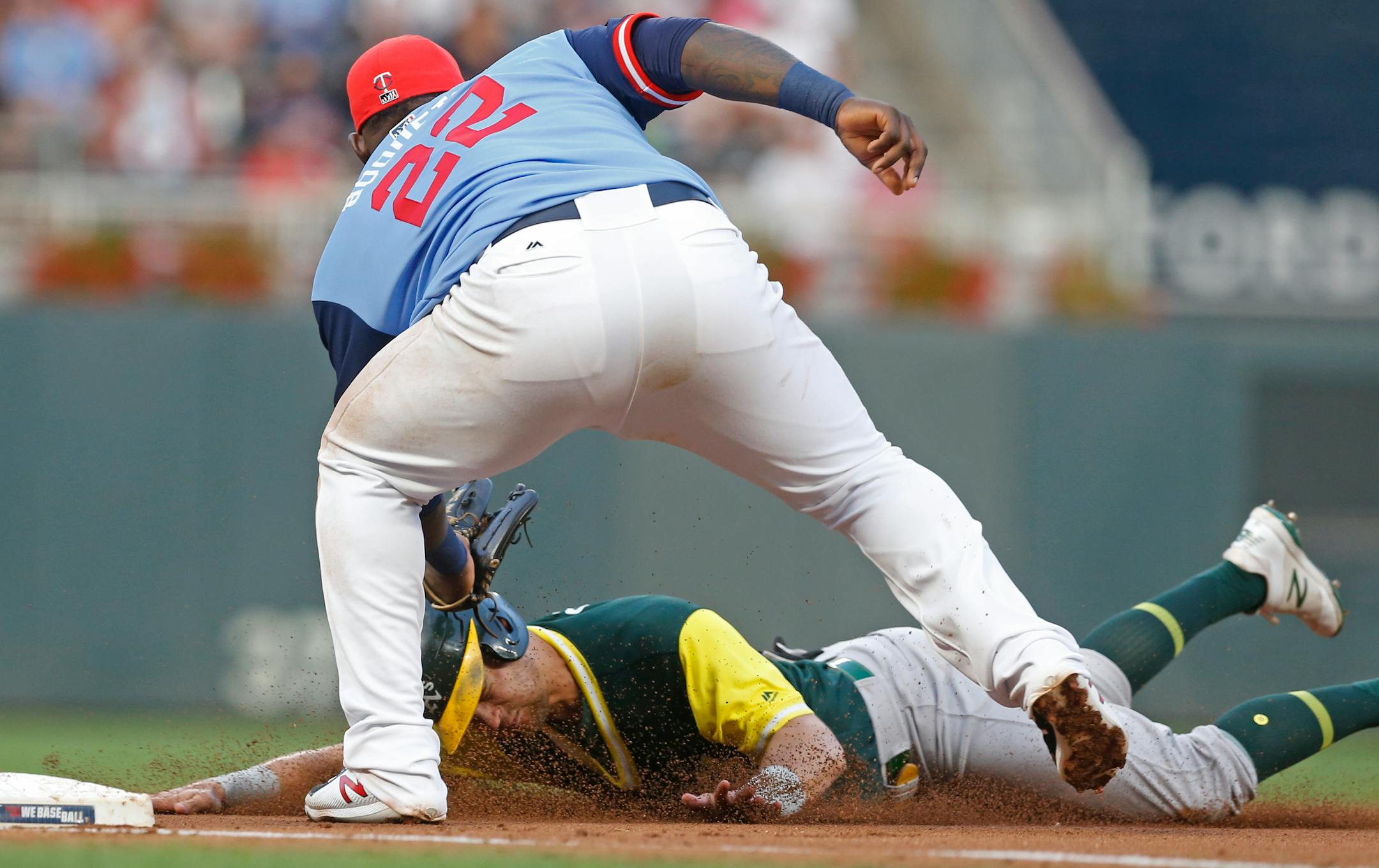 Oakland Athletics' Chad Pinder, bottom, is tagged out at third base by Minnesota Twins third baseman Miguel Sano
