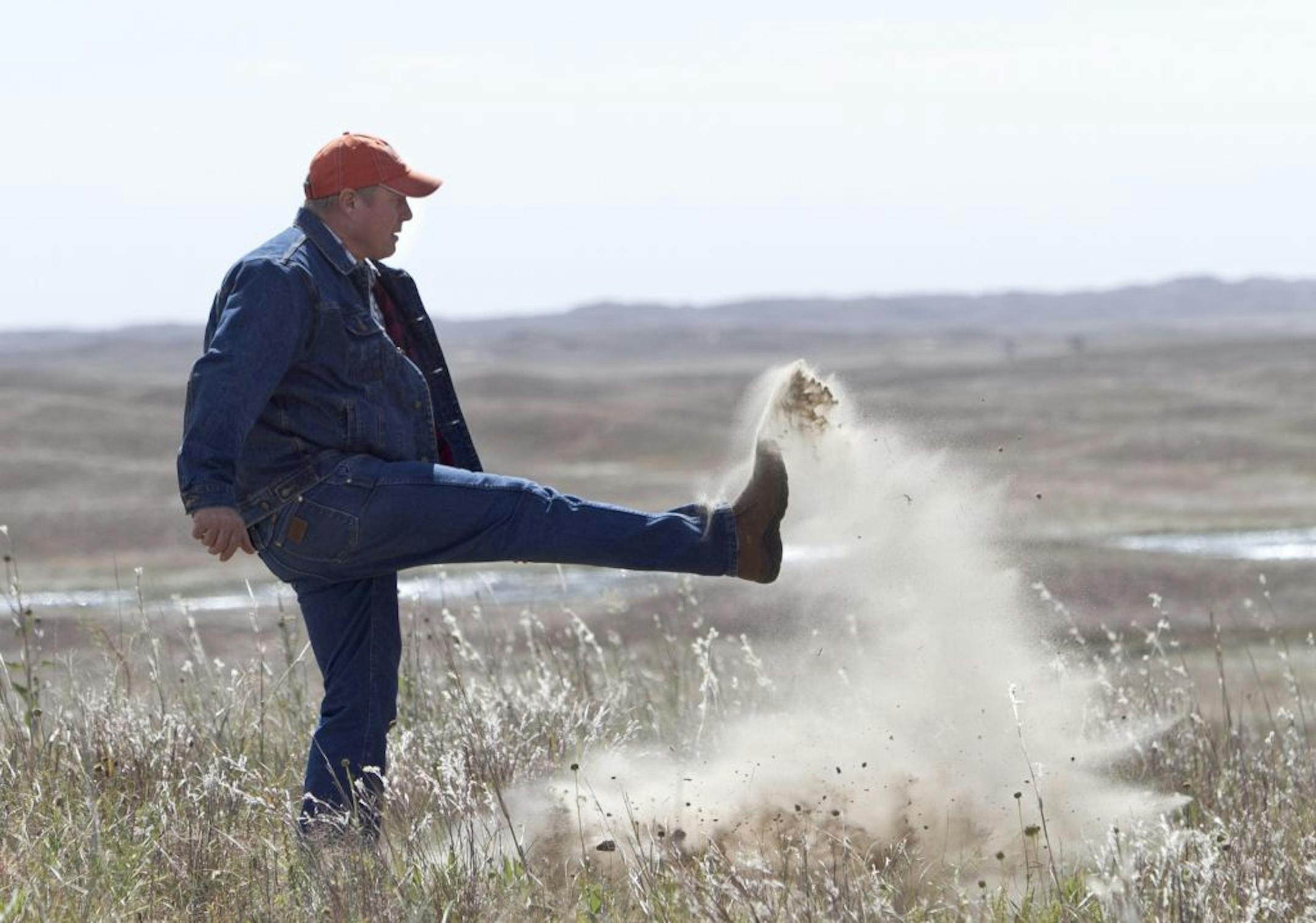 Atkinson, Neb., rancher Bruce Boettcher, top, who opposes the Keystone XL pipeline, kicked up sand on his land to demonstrate the fragility of the sandhills near the planned route.