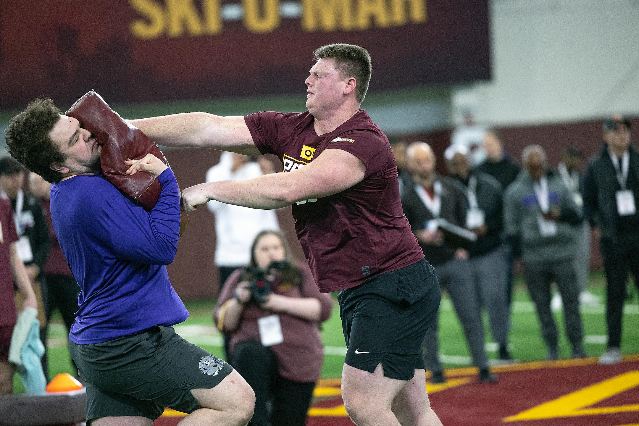 Minnesota center John Michael Schmitz, right, performs for scouts during the Minnesota Pro Day.
