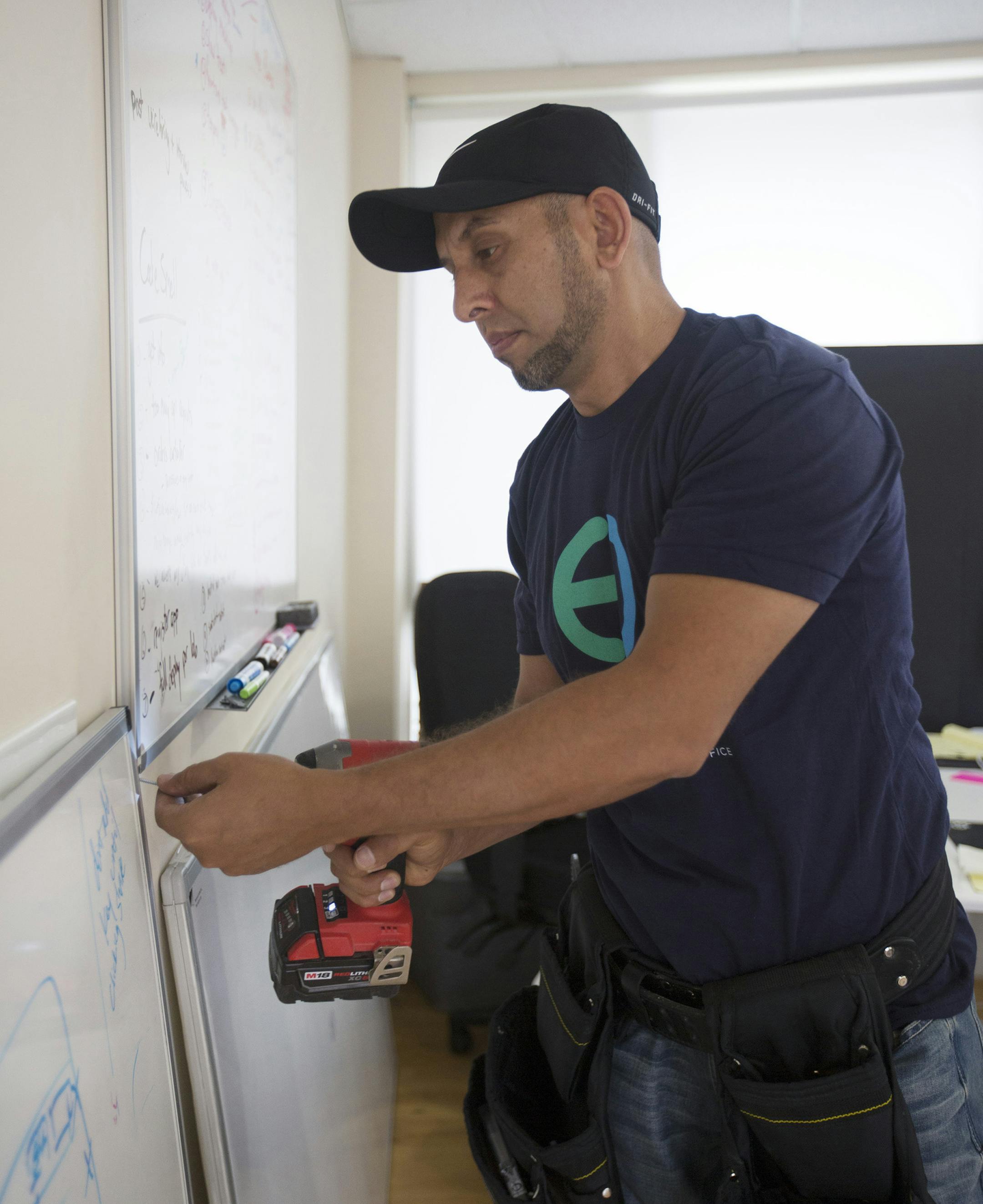 Eden employee Safi Majidzadah prepares to hang a whiteboard at a startup in Palo Alto, Calif. Eden recently moved its workers from independent contractors to employees. (Patrick Tehan/Bay Area News Group/TNS) ORG XMIT: 1190297
