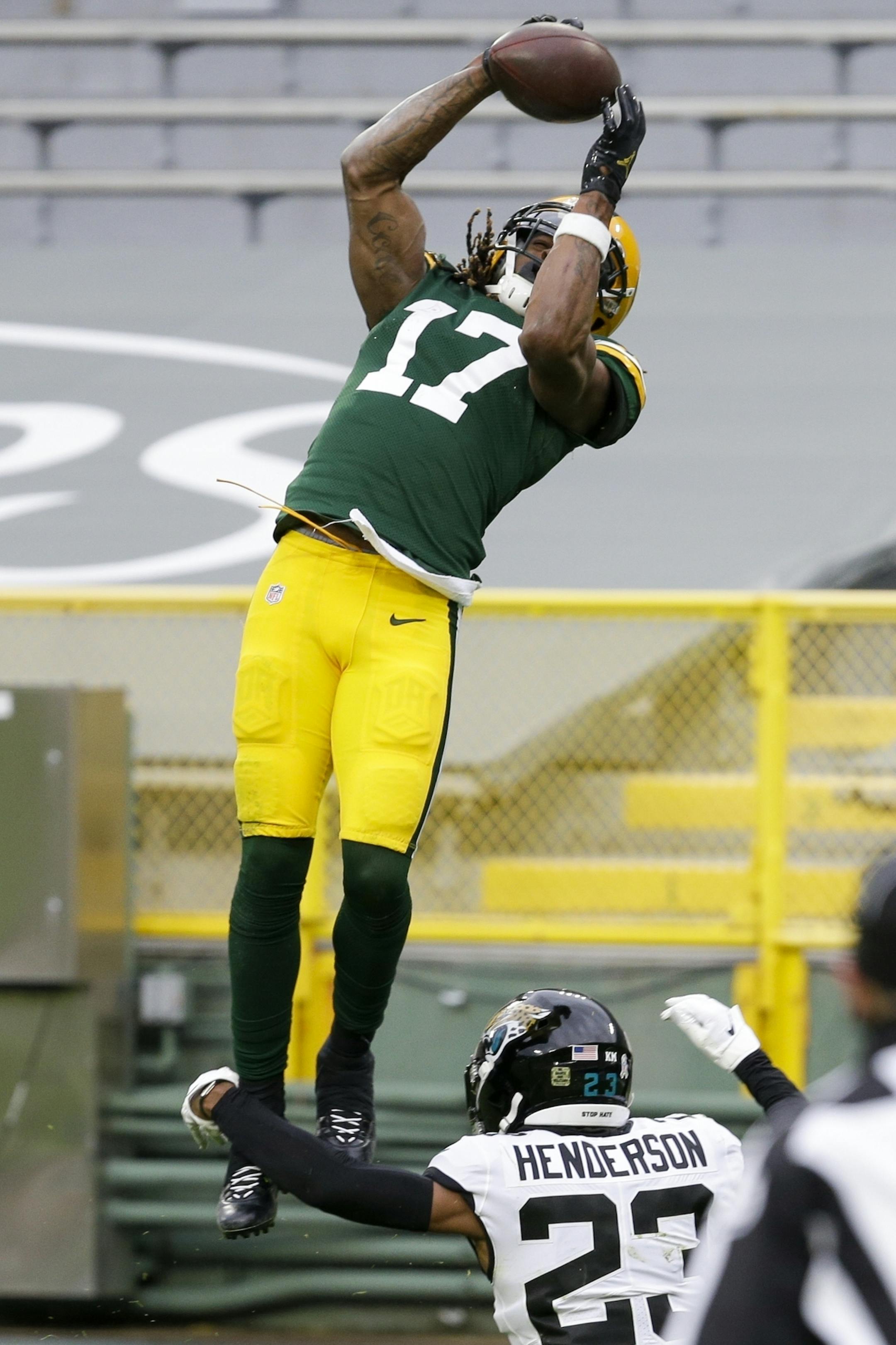 Green Bay Packers' Davante Adams goes over Jacksonville Jaguars' C.J. Henderson for a touchdown catch during the second half of an NFL football game Sunday, Nov. 15, 2020, in Green Bay, Wis. The Packers won 24-20. (AP Photo/Mike Roemer)