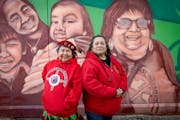 Local American Indian Movement directors Lisa Bellanger, left, Jackie Nadeau, right, stand in front of a mural, in Minneapolis, Minn., on Friday, Feb.