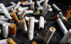 FILE - This Friday, April 7, 2017, file photo, shows cigarette butts discarded in an ashtray outside a New York office building. Decades after they we