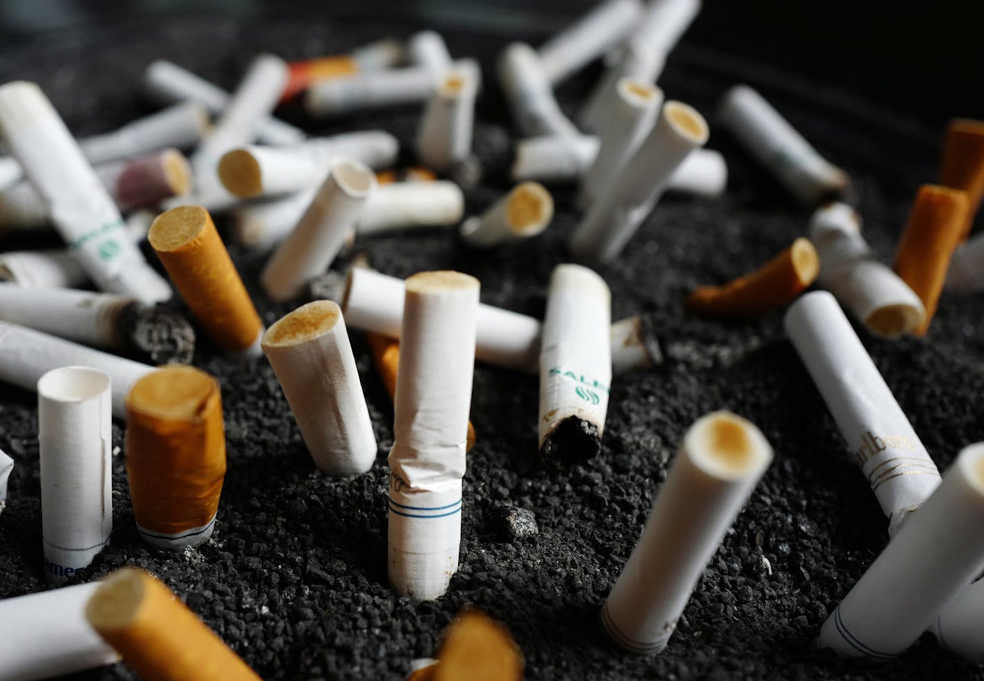 FILE - This Friday, April 7, 2017, file photo, shows cigarette butts discarded in an ashtray outside a New York office building. Decades after they were banned from the airwaves, Big Tobacco companies are returning to prime-time television, but not by choice. Under court order, the tobacco industry for the first time will be forced to advertise the deadly, addictive effects of smoking, more than 11 years after a judge ruled that the companies had misled the public about the dangers of cigarettes