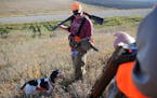 FILE - In this Oct. 18, 2014 file photo, Jason Nomsen, of Sioux Falls, S.D., talks with his dad, David Nomsen, director of the Pheasants Forever South