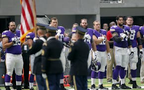 Minnesota Vikings players stand on the field during the playing of the national anthem before an NFL preseason football game against the San Diego Cha