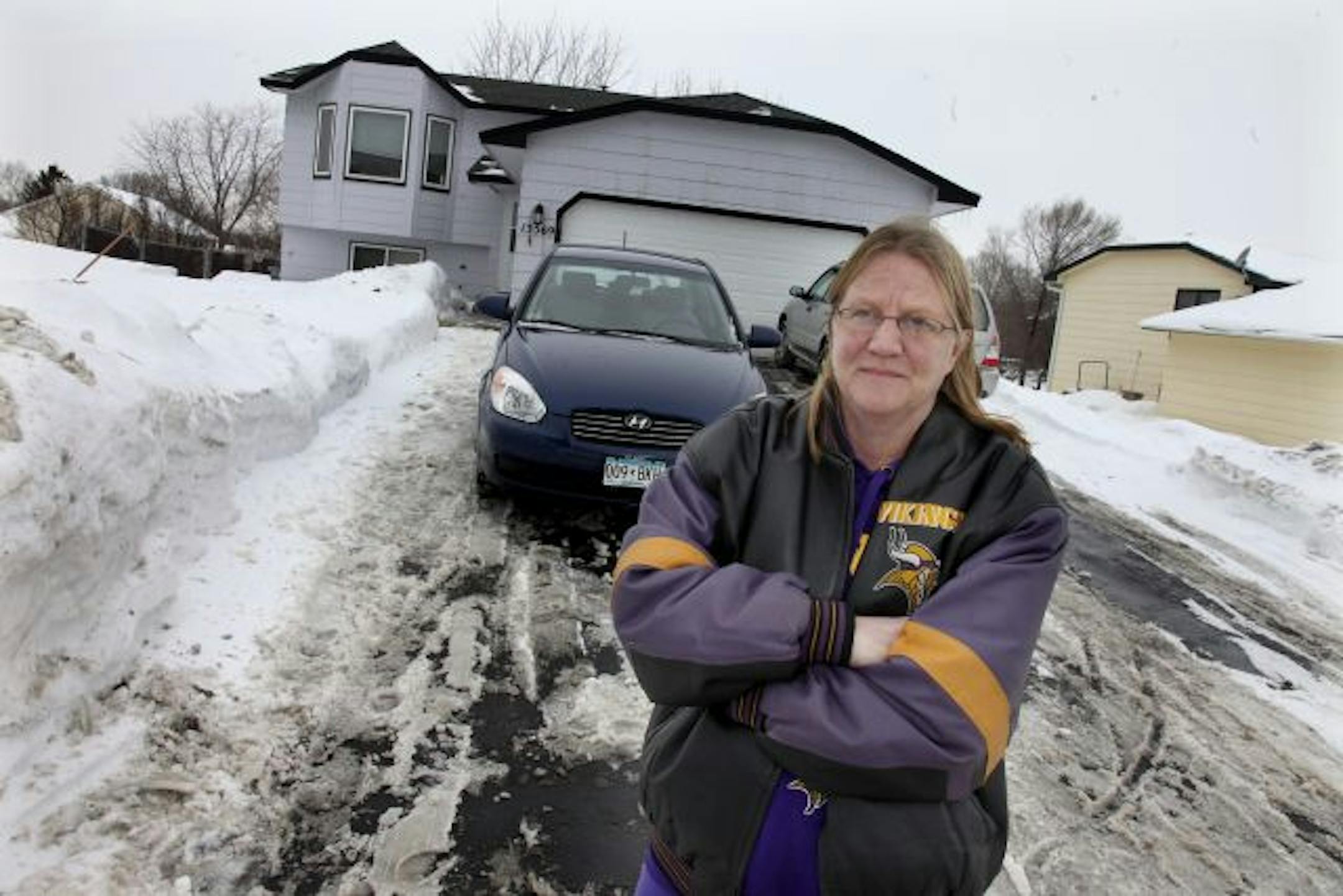 Julie Sucky stood at the edge of her driveway, far away from where her car stood parked and where the city plowed and damaged her vehicle with snow.