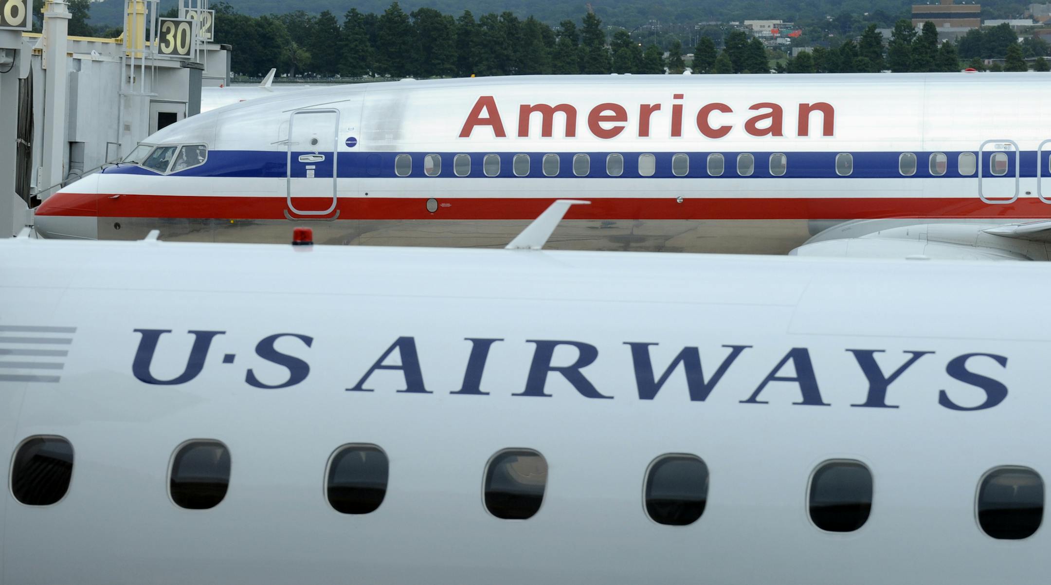 An American Airlines plane and a US Airways plane at parked at Washington's Ronald Reagan National Airport , Tuesday, Aug. 13, 2013.