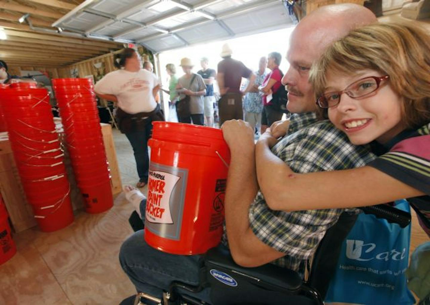 Destany Cleland gave her dad, Eugene, a hug in the Home Depot building after he received a free five-gallon bucket at the State Fair. The Clelands are from Jackson, Minn.