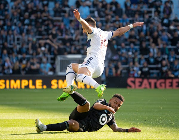 Vancouver Whitecaps defender Luís Martins (14) leapt over Minnesota United defender D.J. Taylor (27) after Taylor took the ball from him in the first