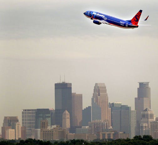 A Sun Country airplane made its way over the Minneapolis skyline early Friday, July 22, 2011, after taking off from the Humphrey terminal in Bloomington, MN.] (ELIZABETH FLORES/STAR TRIBUNE) ORG XMIT: MIN2012091818201199