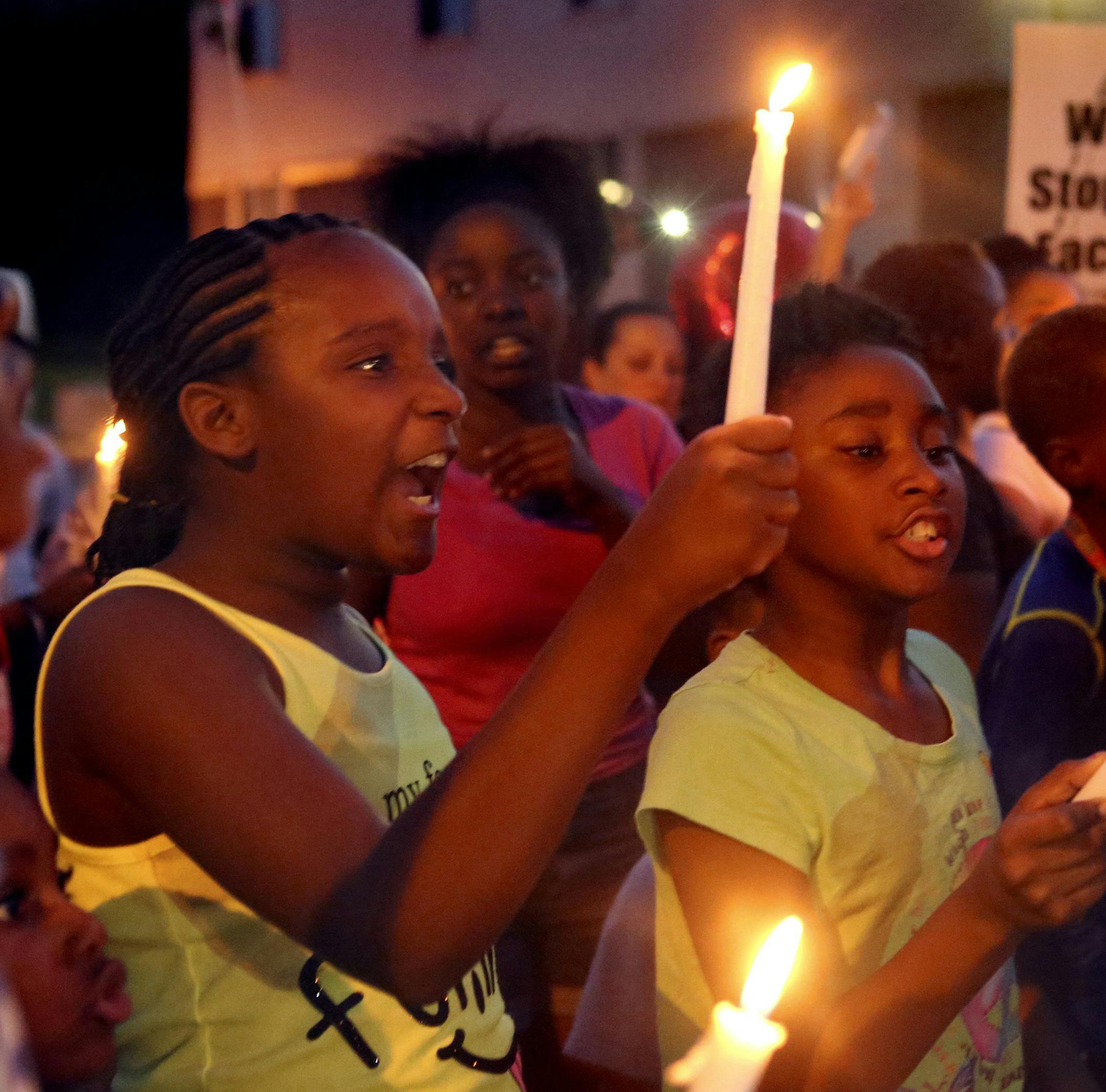 Best friends and neighbors Destiny Sonnier, 9, and Akeelah Kelly, 8, shout, "Justice for Jamyla!" during a community march against violence for Jamyla Bolden that stopped in front of the Mike Brown memorial on Friday, Aug. 20, 2015. Both girls live on Ellison Avenue and lived through a year of Mike Brown protests. (Laurie Skrivan/St. Louis Post-Dispatch/TNS)