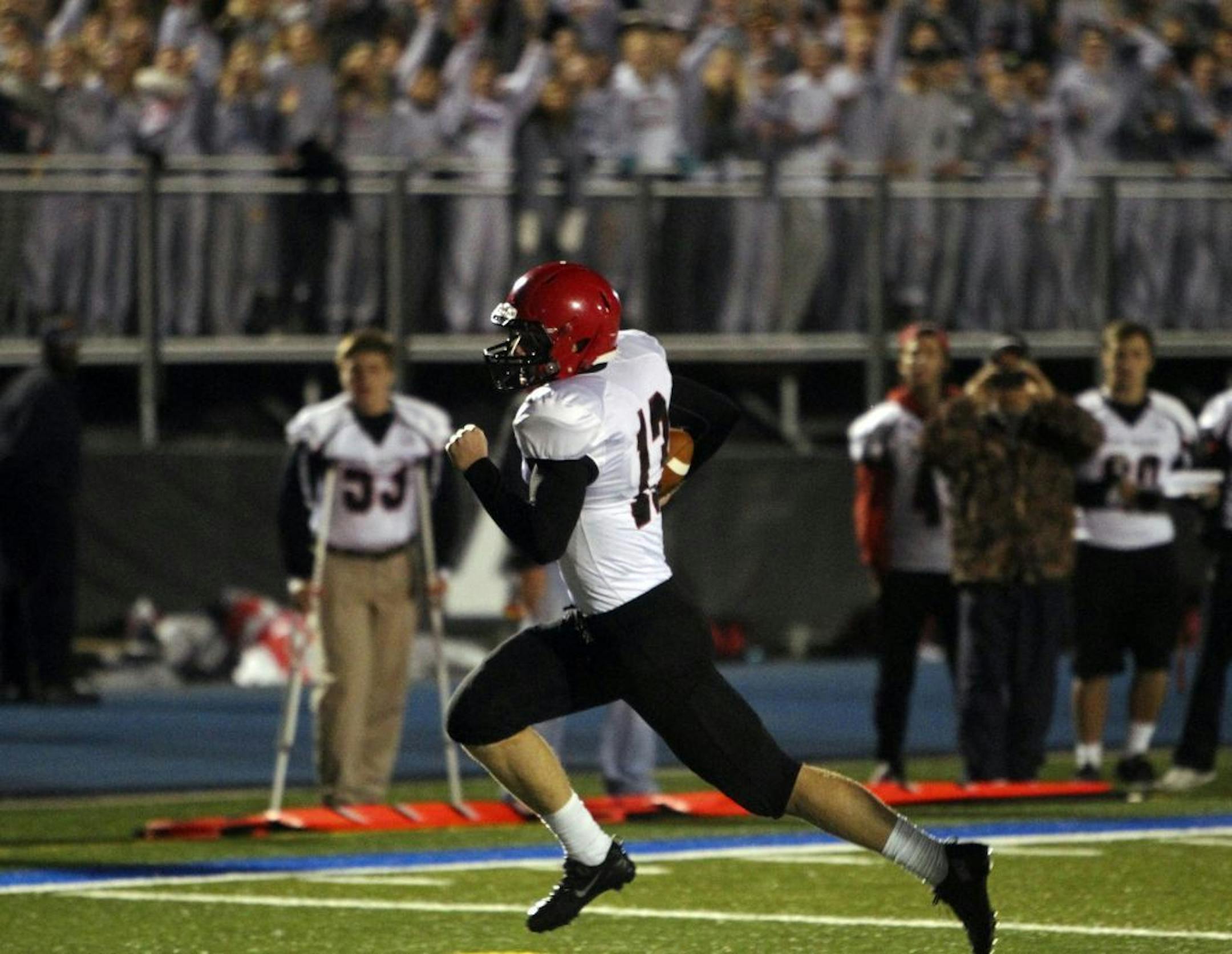Eden Prairie quarterback Ryan Connelly (13) rolls into the end zone on a first quarter TD run against Minnetonka
