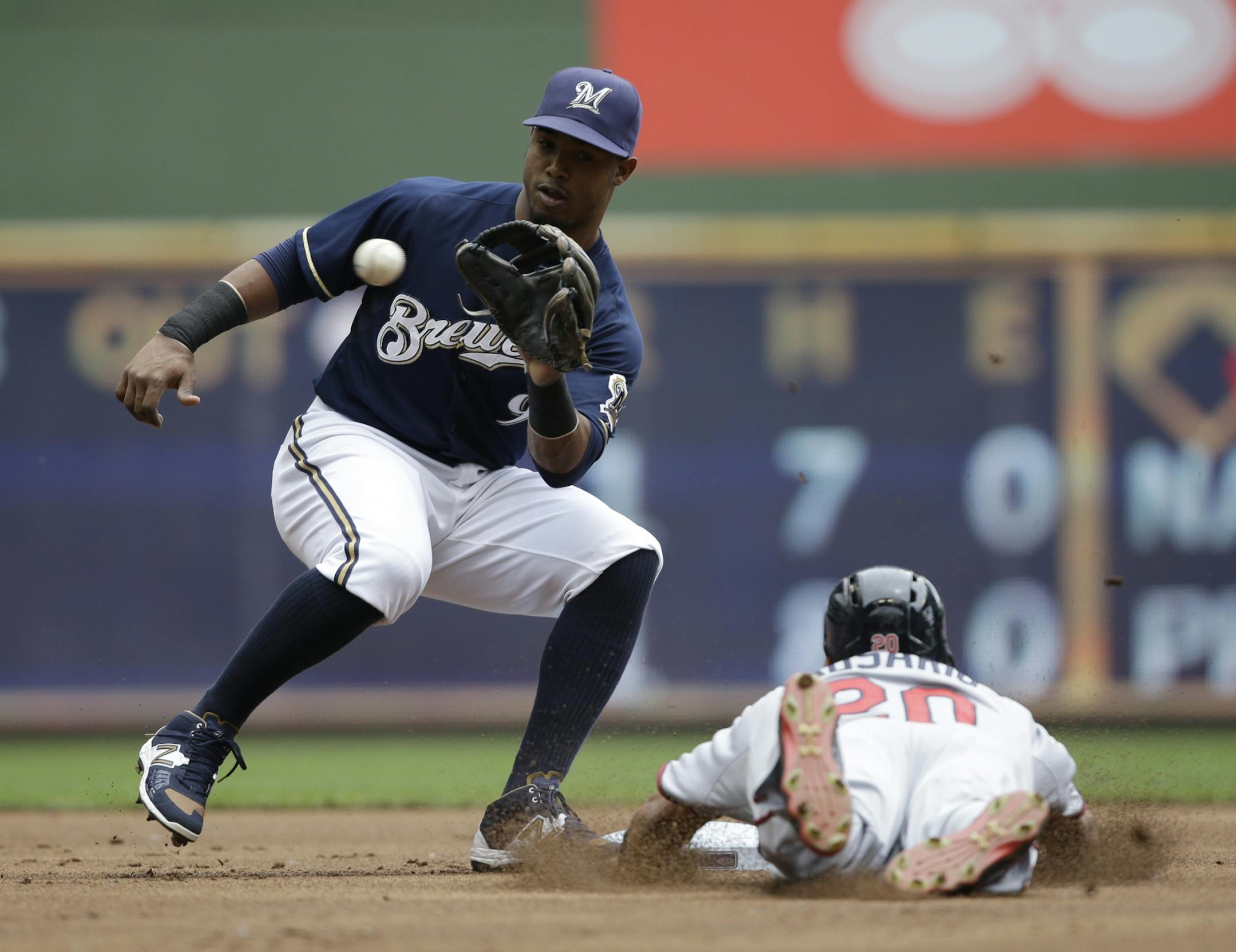Milwaukee Brewers' Jean Segura, left, awaits the ball to tag out Minnesota Twins' Eddie Rosario (20) who was trying to steal second base during the first inning of a baseball game Sunday, June 28, 2015, in Milwaukee.