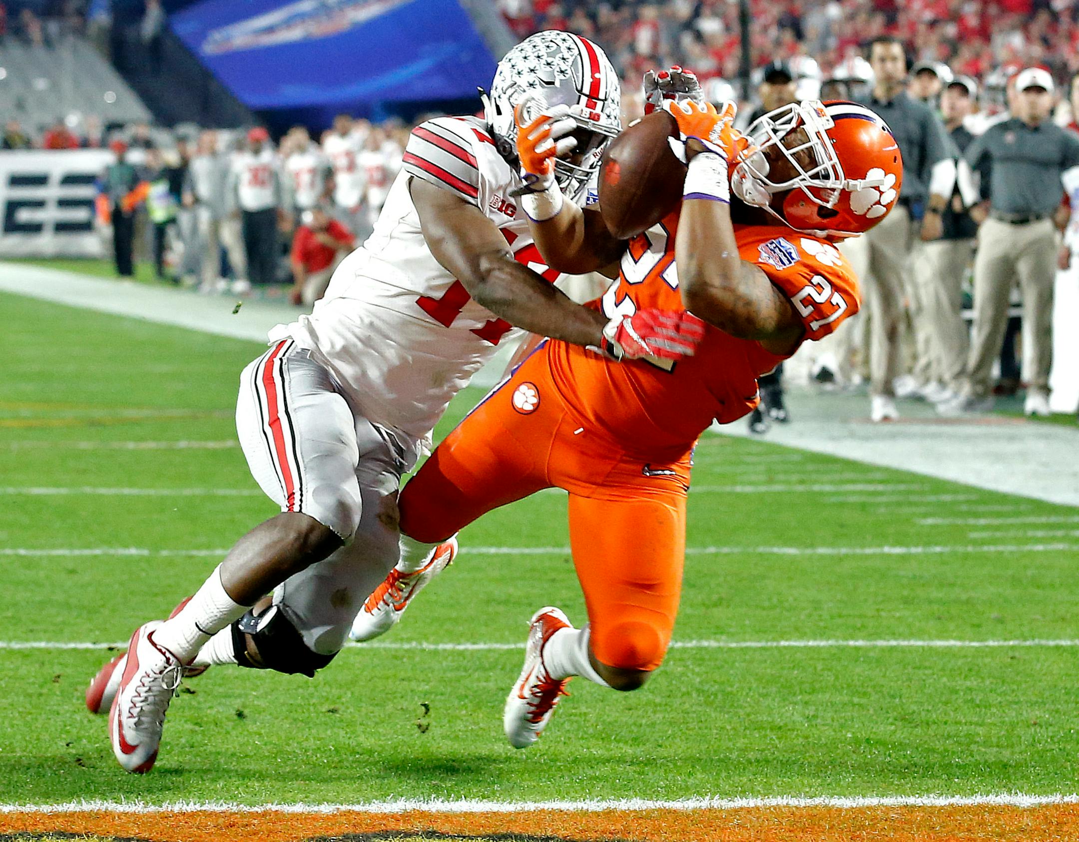 Clemson running back C.J. Fuller (27) makes a touchdown catch as Ohio State cornerback C.J. Saunders (17) defends during the first half of the Fiesta Bowl NCAA college football playoff semifinal, Saturday, Dec. 31, 2016, in Glendale, Ariz. (AP Photo/Ross D. Franklin)