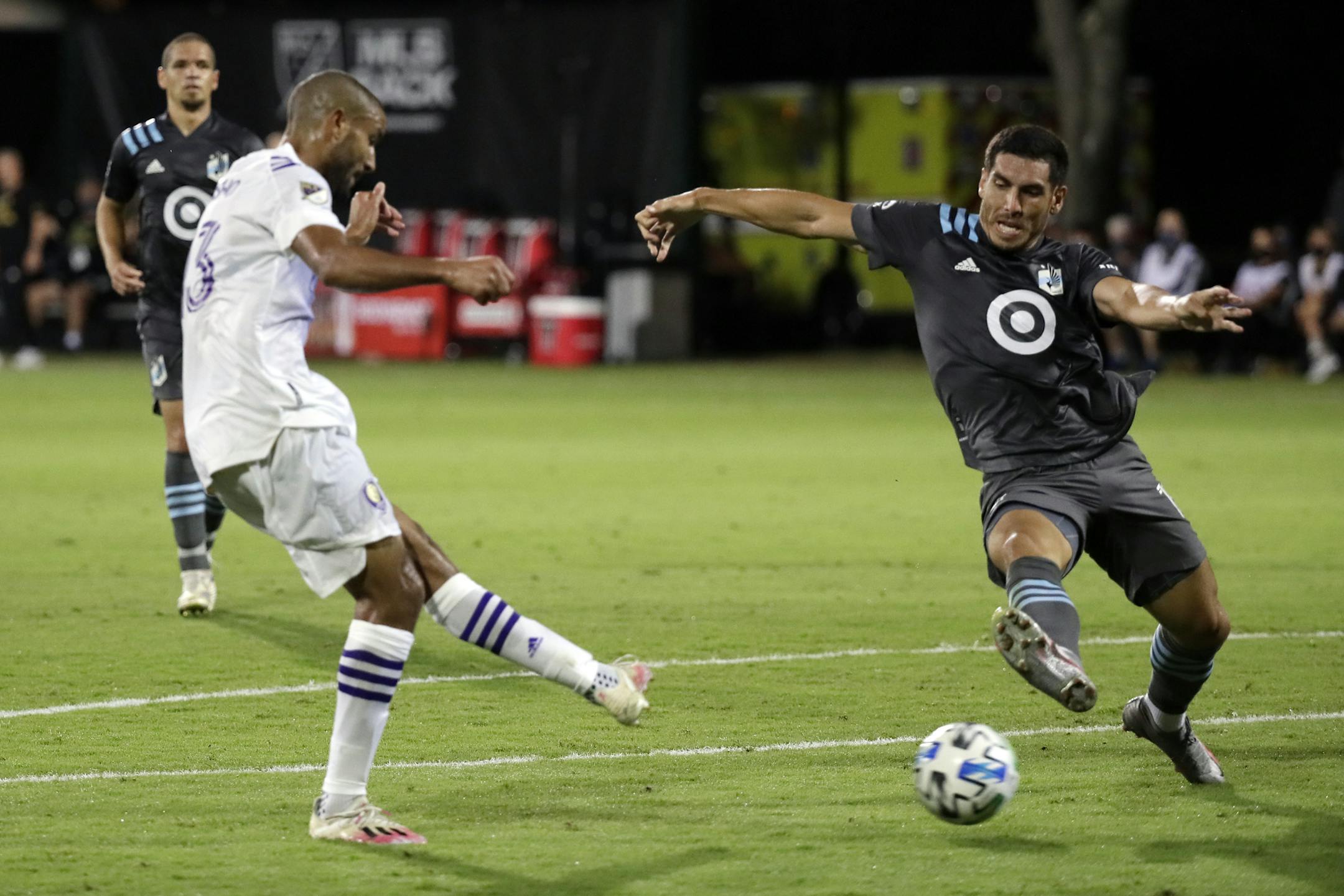 Minnesota United defender Michael Boxall, right, tries to block a shot by Orlando City forward Tesho Akindele, left, during the first half of an MLS soccer match, Thursday, Aug. 6, 2020, in Kissimmee, Fla. (AP Photo/John Raoux)