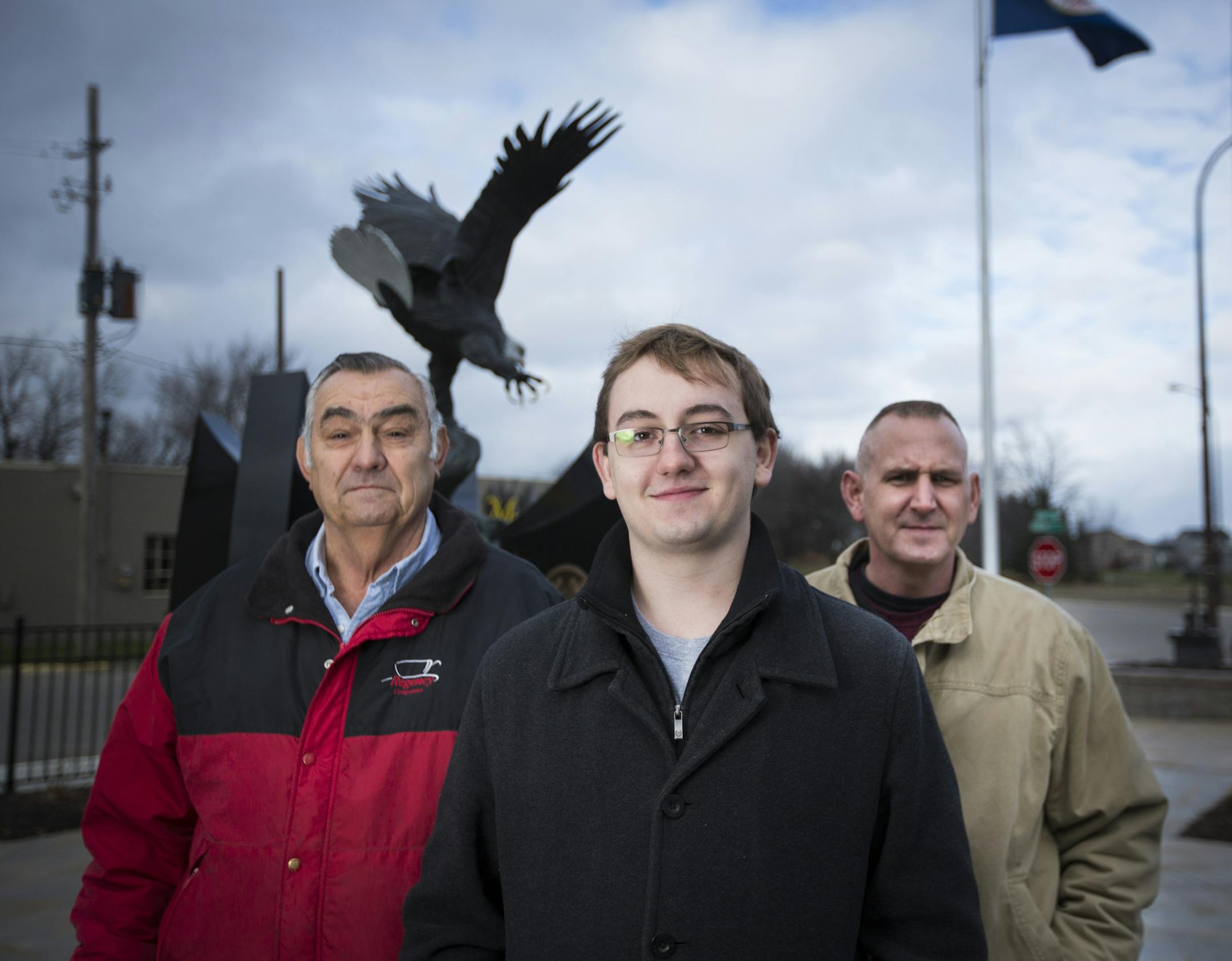 Tyler Skluzacek, center, at the veterans memorial in Lonsdale, Minn., with his grandfather John Skluzacek, left, and father, Patrick Skluzacek
