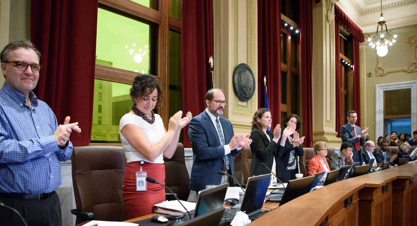 Some Minneapolis City Council members stood to applaud after the council unanimously approved an ordinance that will require most city businesses to provide paid sick leave to workers, Friday, May 27, 2016, in Minneapolis. (Glen Stubbe/Star Tribune via AP) MANDATORY CREDIT; ST. PAUL PIONEER PRESS OUT; MAGS OUT; TWIN CITIES LOCAL TELEVISION OUT