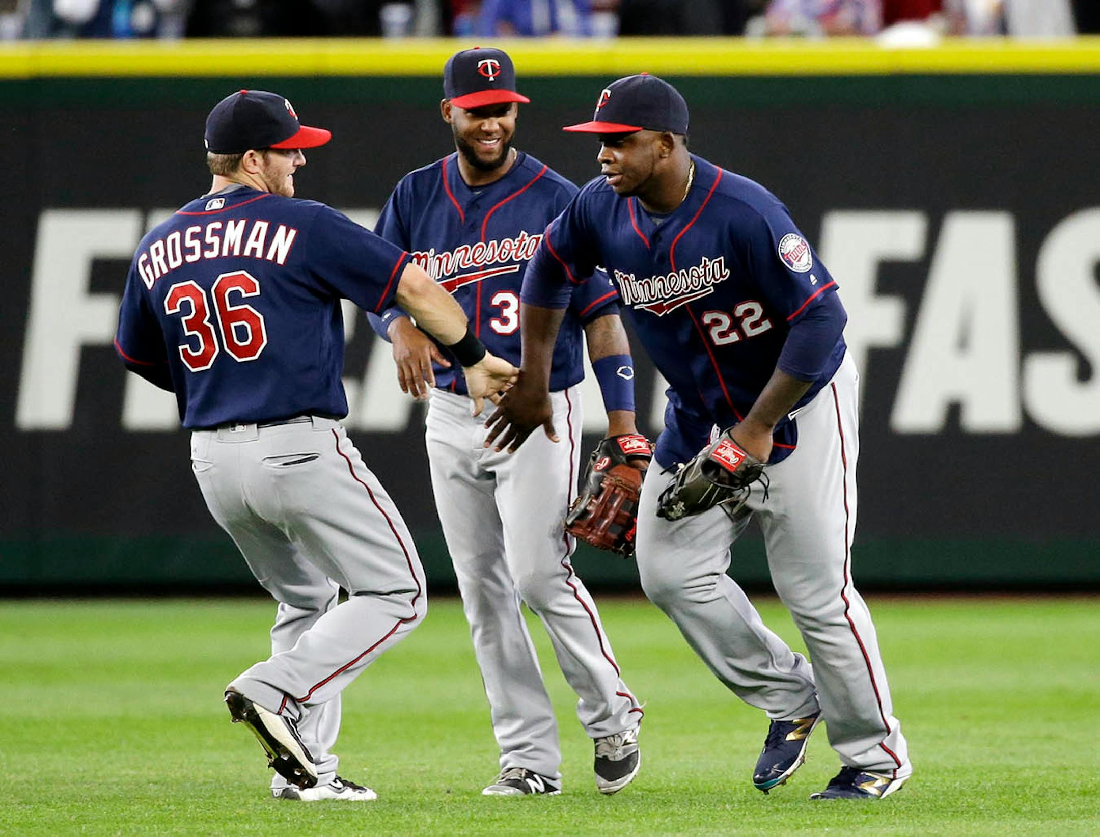 Minnesota Twins outfielders Robbie Grossman (36), Danny Santana and Miguel Sano (22) share congratulations after they defeated the Seattle Mariners in a baseball game Sunday, May 29, 2016, in Seattle.