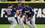Minnesota Twins outfielders Robbie Grossman (36), Danny Santana and Miguel Sano (22) share congratulations after they defeated the Seattle Mariners in