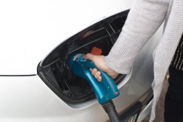 Rhea O'Connor removes the nosel of the Fast Charger after charging her Nissan Leaf, an electric car, at a BP off of Lyndale Ave. S, is the only servic