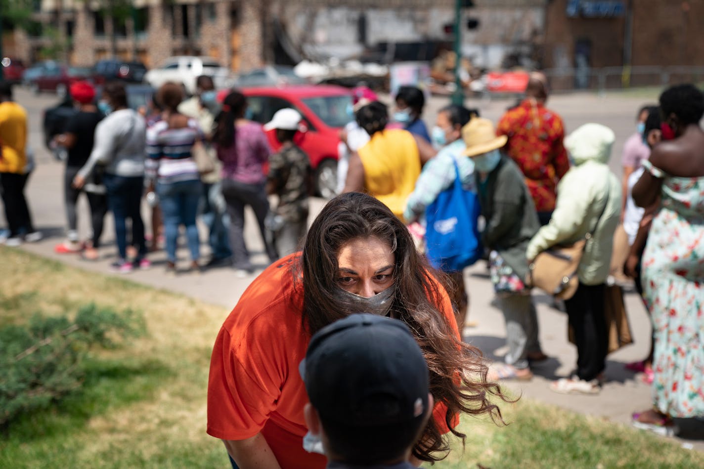 Kelly Sherman-Conroy checked in on a little boy who was waiting in the shade while others stood in line for food at Holy Trinity Lutheran Church, which has been a major food distribution site since Lake Street burned. ] GLEN STUBBE • glen.stubbe@startribune.com Friday, June 26, 2020 Kelly Sherman-Conroy felt the tension and heartache following the protest violence that erupted in the Twin Cities, and concluded that people were aching for more than food and emergency relief. So the Lutheran activ