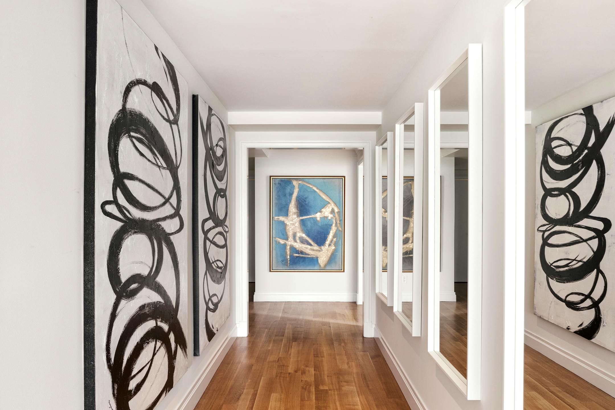 A hallway is highlighted through groupings of even-numbered artwork and mirrors. (Scott Morris/TNS)