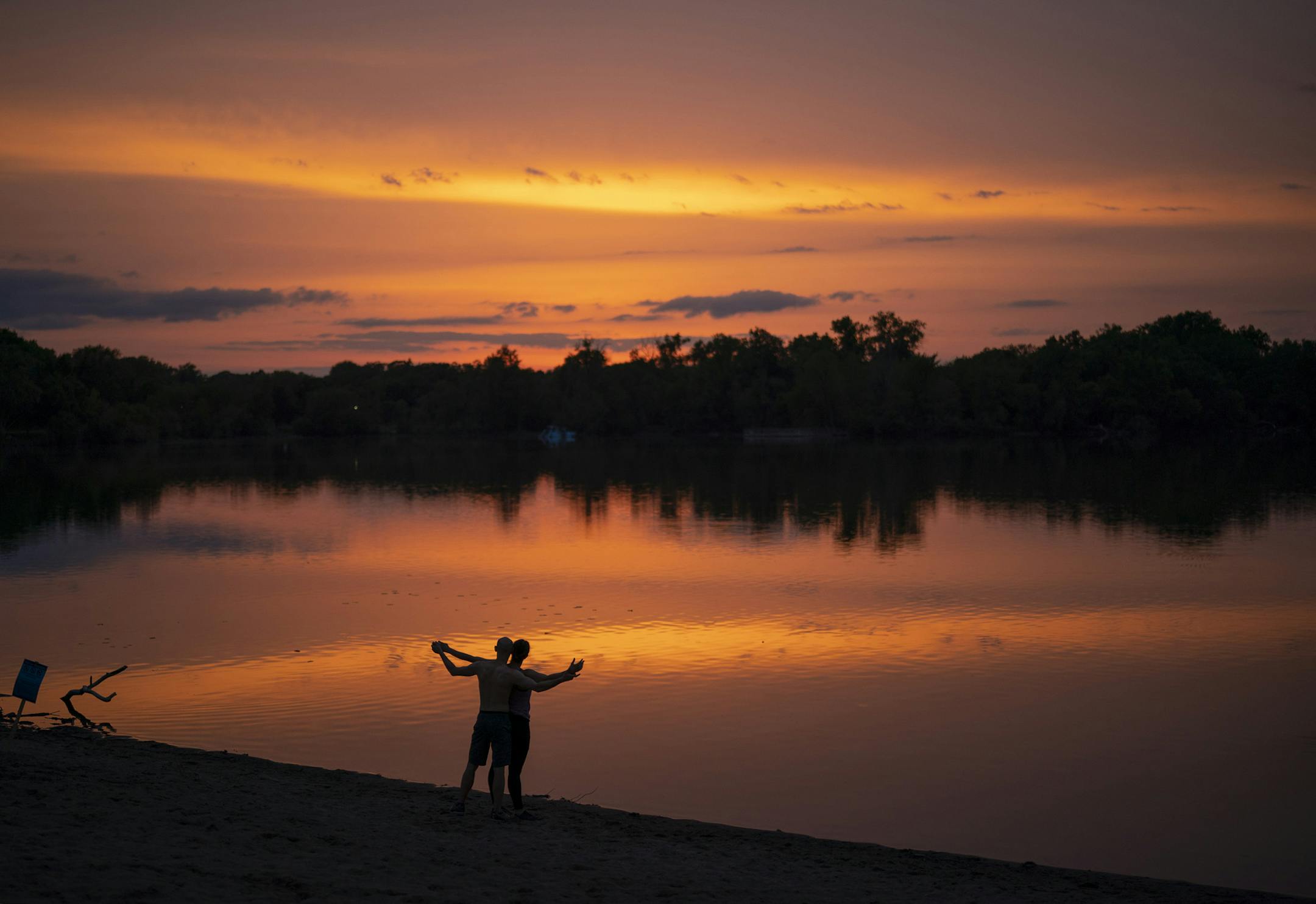 Katie Strand and her partner in life and in dance, Peter Everest, had a moment together at the South Beach at Cedar Lake at sunset Sunday night. The couple participated in a few different kinds of dance, before the pandemic put all that to a stop. "I miss dancing more than anything else," Katie Strand said. ] JEFF WHEELER • Jeff.Wheeler@startribune.com After threatening rain most of the day, at day's end a beautiful sunset lit up the sky Sunday afternoon, May 24, 2020 at Cedar Lake in Minneapoli