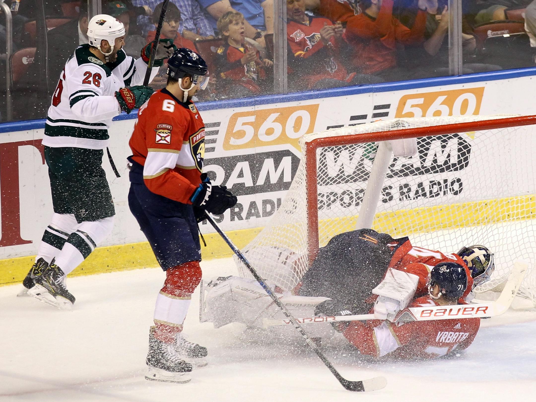Minnesota Wild's Daniel Winnik, left, celebrates after scoring a goal against Florida Panthers goalie James Reimer, top right, as Panthers' Florida Panthers' Radim Vrbata, bottom right, of the Czech Republic, slides into Reimer and Alex Petrovic (6) looks on during the second period of an NHL hockey game, Friday, Dec. 22, 2017, in Sunrise, Fla. (AP Photo/Luis M. Alvarez