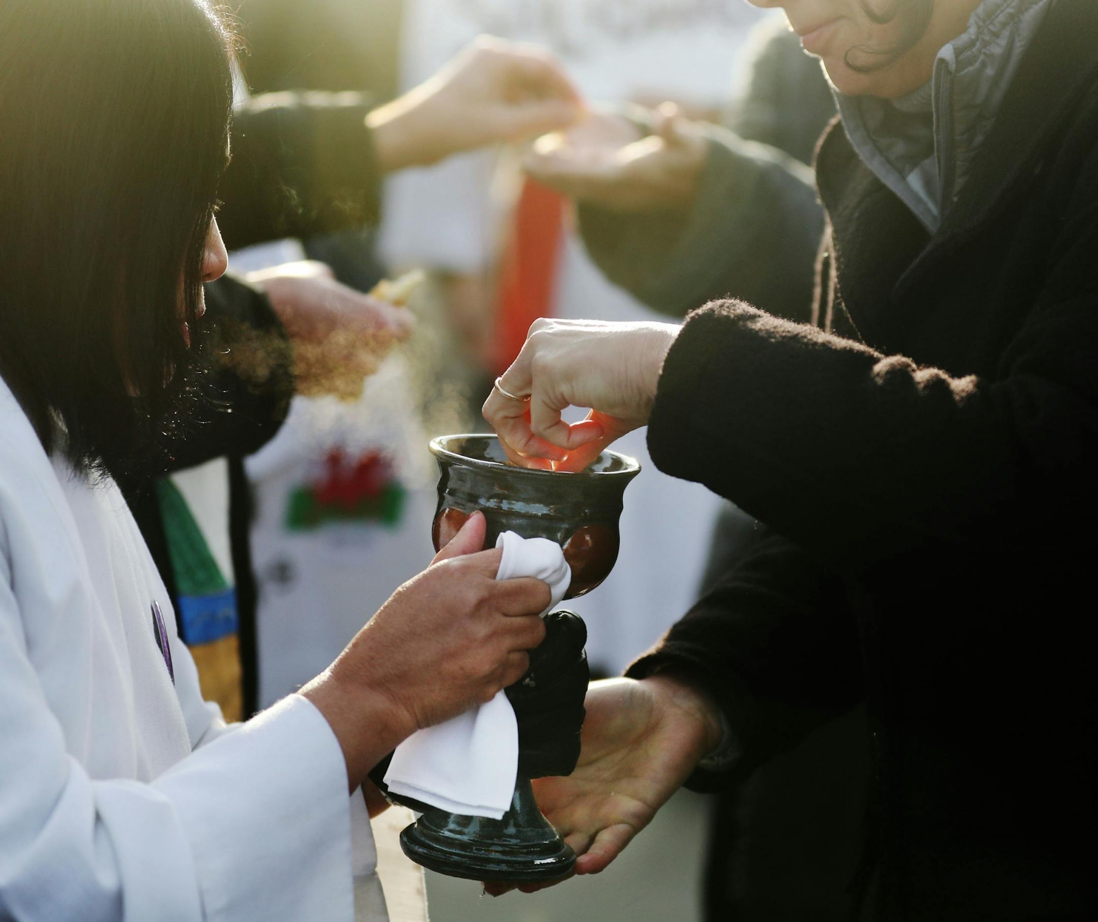 Lay person Hser Moo, left, offered wine during a communion outside the Whipple Federal Building Tuesday, Oct. 29, 2019, in St. Paul, MN. Clergy and protestors gathered for a service and communion outside the Whipple Federal Building and to protest the naming of the building after the Episcopal bishop because deportations and other actions at the courthouse are in opposition to the beliefs of the Episcopal church, they stated.