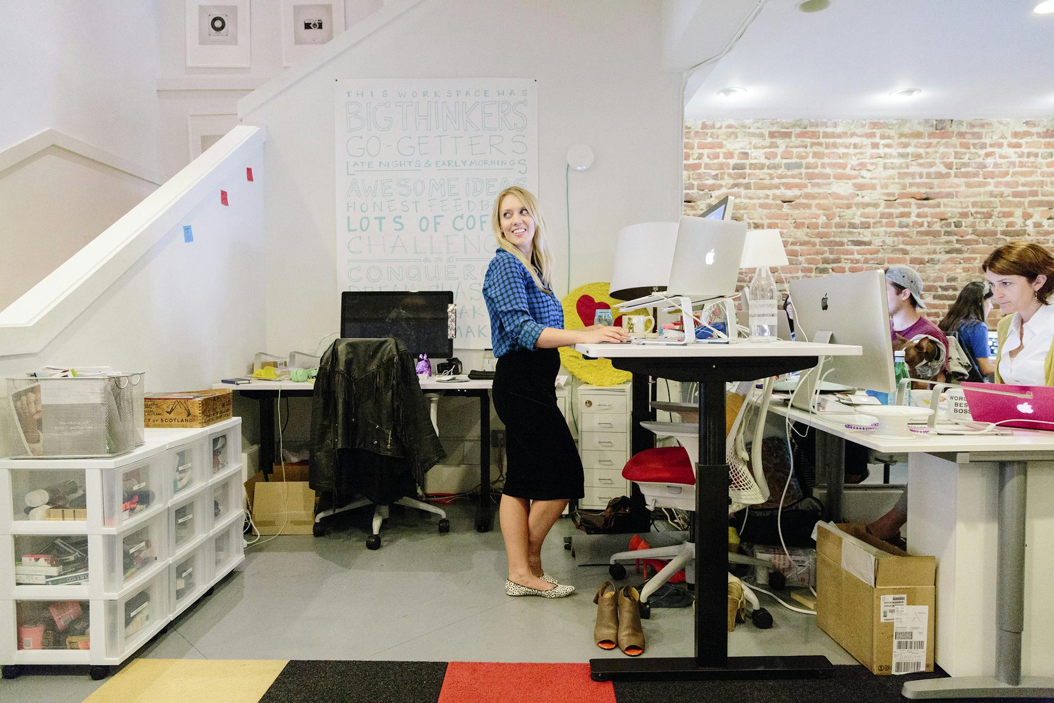 Lisa Raphael, who leads the editorial team at the website Brit & Co, hopes working at a standing desk will help her scoliosis and back pain in San Francisco, Aug.18, 2015. With the rise of the standing desk, Raphael and other white-collar workers are considering how to dress for it, even re-evaluating their choices of what they wear to the office entirely. (Jason Henry/The New York Times)