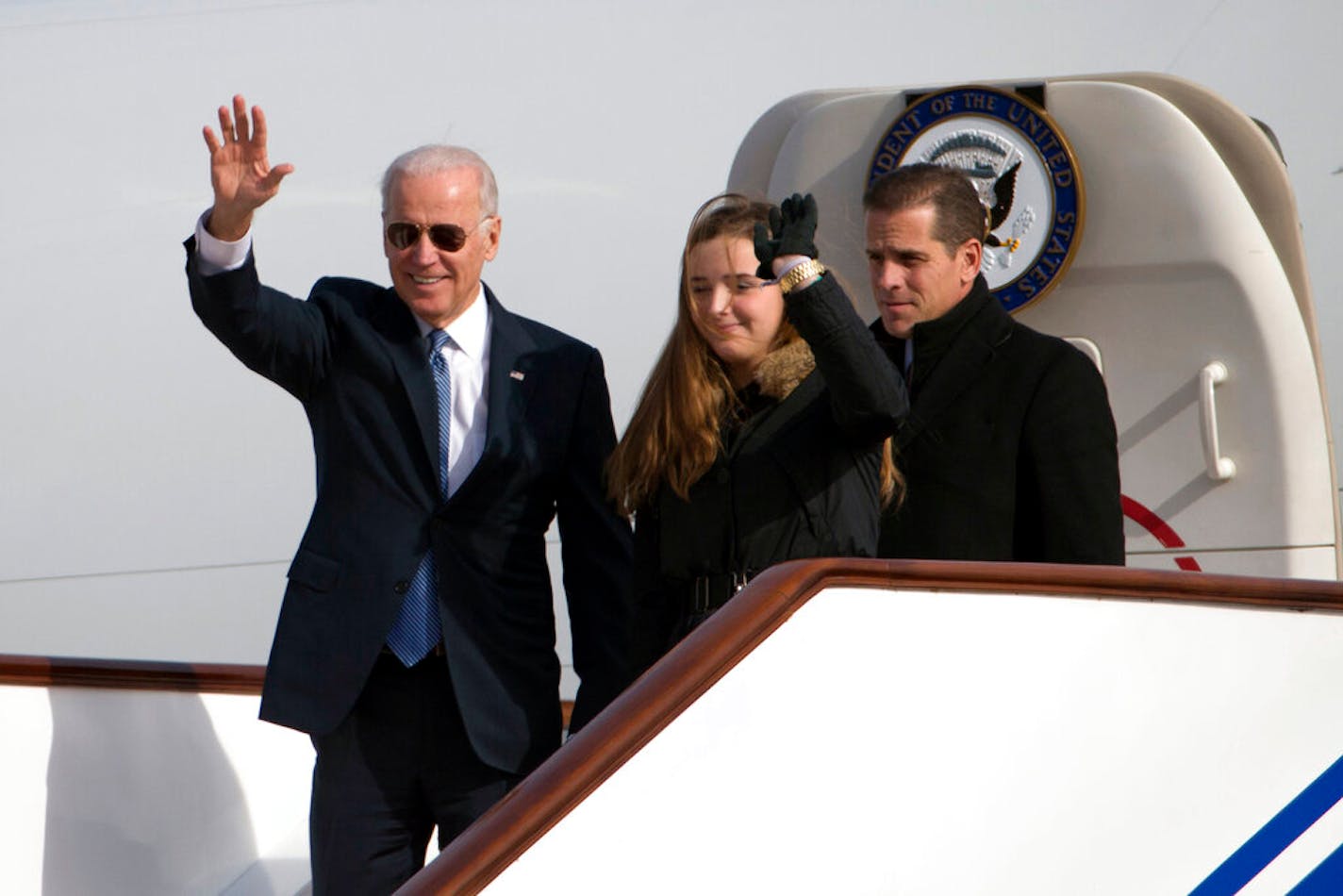 FI:LE - In this Wednesday, Dec. 4, 2013 file photo, U.S. Vice President Joe Biden, left, waves as he walks out of Air Force Two with his granddaughter Finnegan Biden and son Hunter Biden at the airport in Beijing, China. On Friday, Oct. 25, 2019, The Associated Press reported on stories circulating online incorrectly asserting that Hunter Biden got $1.76 million from taxpayer-funded Amtrak. The son of Democratic presidential candidate and former Vice President, was paid $32,850 during a 31-month tenure on Amtrak's board of directors. (AP Photo/Ng Han Guan, Pool)