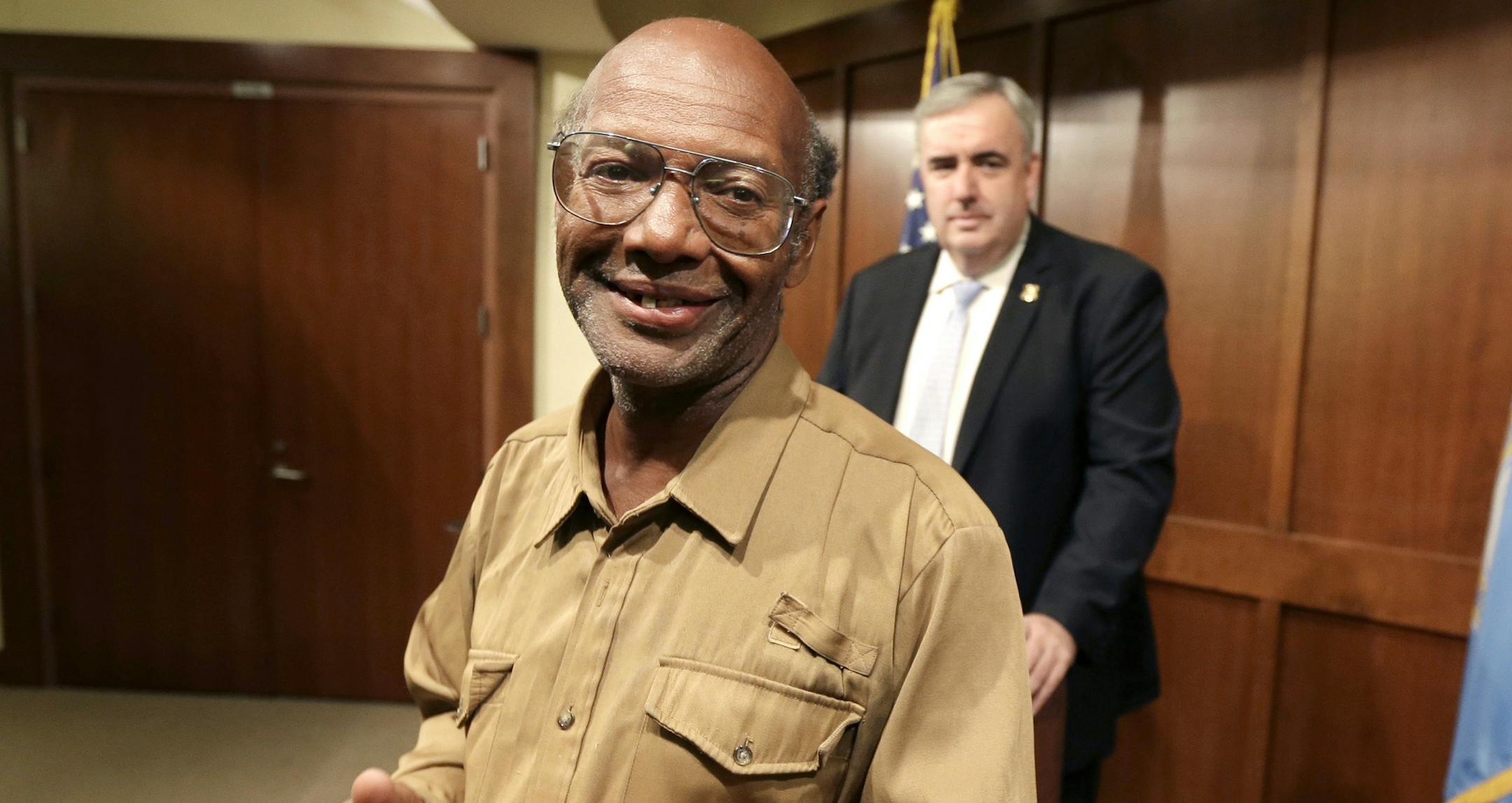 Glen James, of Boston, left, smiles in the direction of members of the media as Boston Police Commissioner Edward Davis, right, looks on during a news conference at the police headquarters, in Boston on Monday, Sept. 16, 2013.
