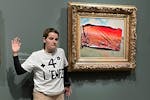 This photo provided by Riposte Alimentaire shows an environmental activist posing by "Poppy Field'' by Claude Monet at the Orsay museum, Saturday, Jun
