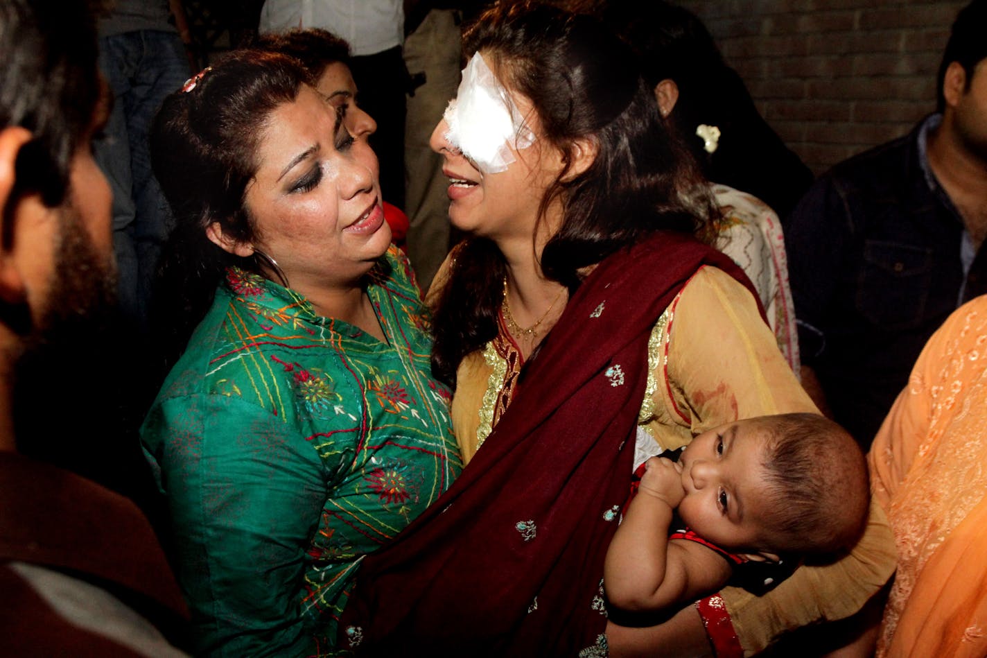 A woman injured in the bomb blast is comforted by a family member at a local hospital in Lahore, Pakistan, Sunday, March, 27, 2016. A bomb blast in a park in the eastern Pakistani city of Lahore has killed tens of people and wounded scores, a health official said. (AP Photo/K.M. Chuadary)