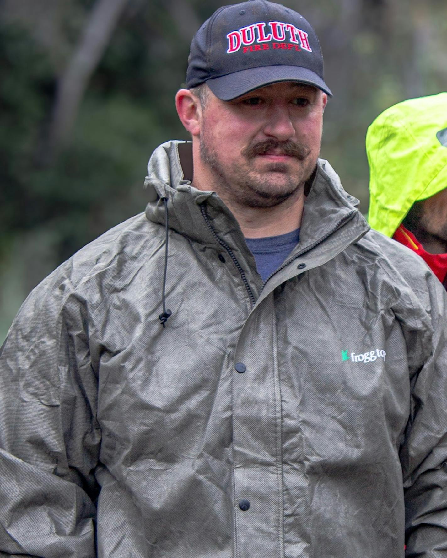 Andy Beck wears outdoor gear walking through the woods.