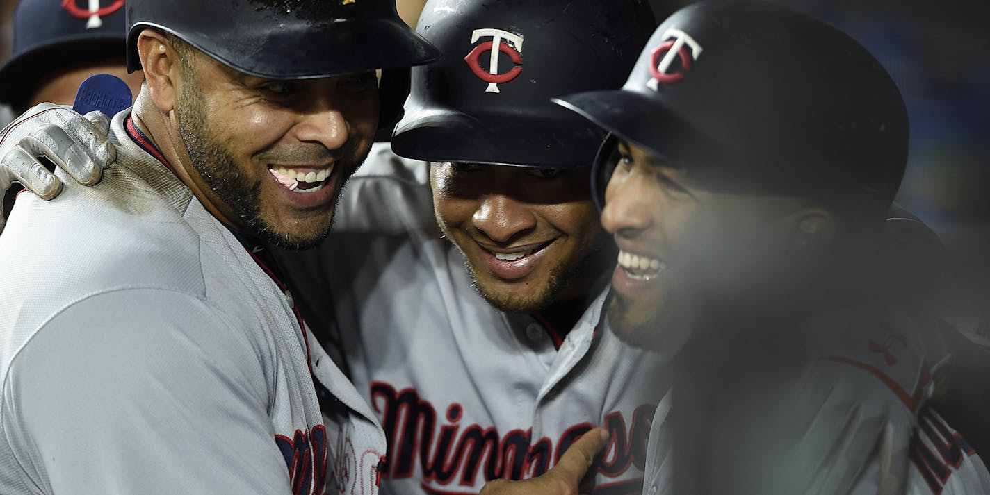 Minnesota Twins Jonathan Schoop, center, is hugged by Eddie Rosario, right, and Nelson Cruz after hitting a three-run home run against the Baltimore Orioles in the fourth inning of the second game of a baseball doubleheader, Saturday, April 20, 2019, in Baltimore. (AP Photo/Gail Burton)