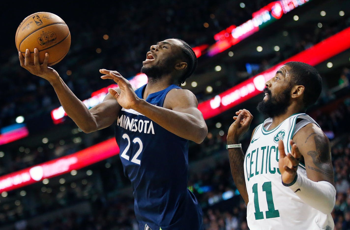 Minnesota Timberwolves' Andrew Wiggins (22) grabs a rebound in front of Boston Celtics' Kyrie Irving (11) during the third quarter of an NBA basketball in Boston, Friday, Jan. 5, 2018.