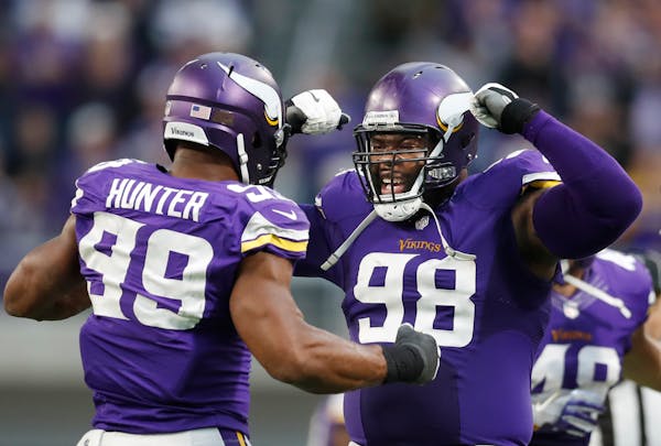Vikings defensive end Danielle Hunter (99) celebrated his last sack of the game on Cardinals quarterback Carson Palmer with defensive tackle Linval Jo