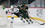 Sharks defenseman Erik Karlsson, left, and Wild defenseman Carson Soucy battled for the puck during the first period of Minnesota’s 5-2 victory at X