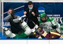 (Left) North Dakota Fighting Hawks forward Riese Gaber (17) and UMD Bulldogs defenseman Louie Roehl (6) fell over the boards and into the North Dakota